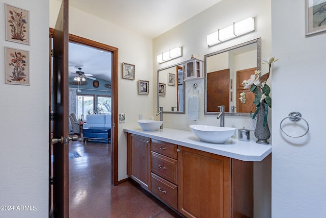 bathroom featuring dual sinks, ceiling fan, large vanity, and concrete flooring