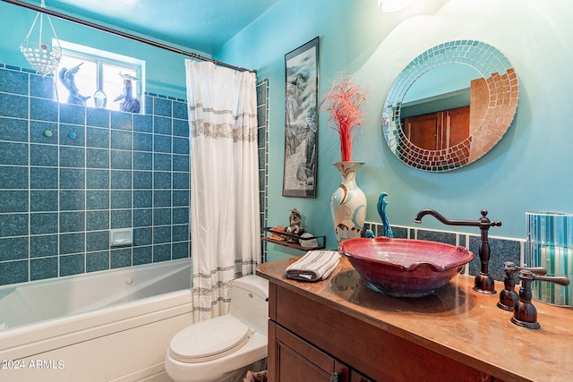 full bathroom featuring shower / tub combo, toilet, and vanity with extensive cabinet space