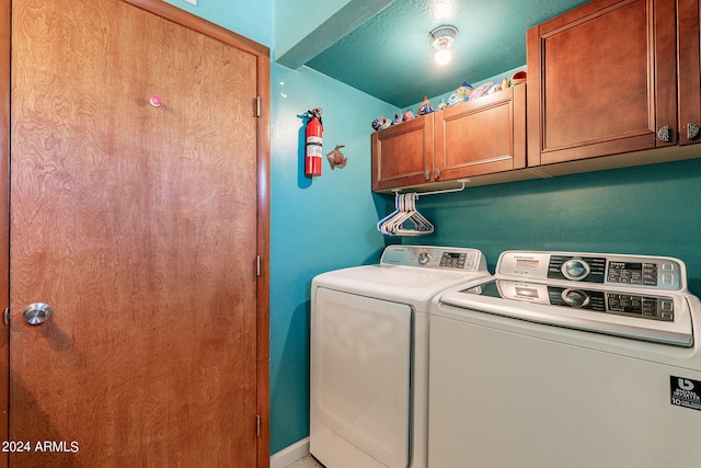 washroom featuring cabinets and separate washer and dryer