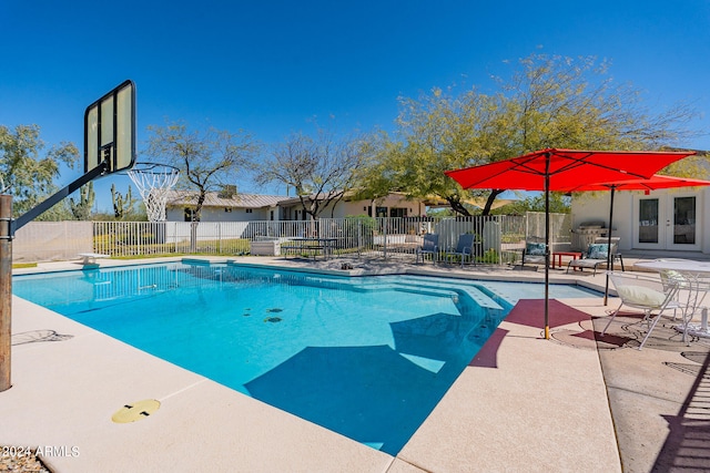 view of pool with a diving board and a patio