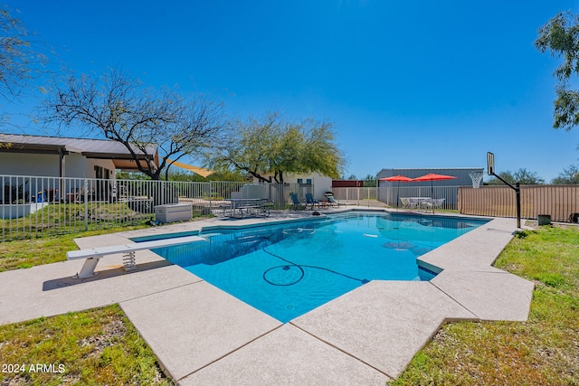 view of pool featuring a diving board and a yard