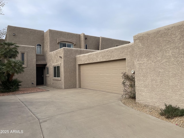 pueblo-style home featuring a garage