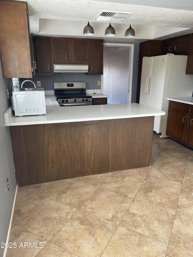 kitchen with dark brown cabinetry, white appliances, kitchen peninsula, and a textured ceiling