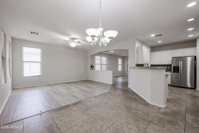 45633 W Mountain View Rd, Maricopa, AZ 85139 - kitchen featuring light tile patterned flooring, stainless steel fridge with ice dispenser, arched walkways, white cabinetry, and visible vents