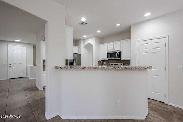 45633 W Mountain View Rd, Maricopa, AZ 85139 - kitchen featuring visible vents, recessed lighting, white cabinetry, arched walkways, and appliances with stainless steel finishes