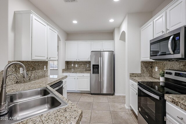 45633 W Mountain View Rd, Maricopa, AZ 85139 - kitchen with backsplash, stainless steel appliances, arched walkways, and a sink