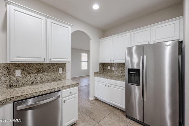 45633 W Mountain View Rd, Maricopa, AZ 85139 - kitchen featuring appliances with stainless steel finishes, tile counters, arched walkways, and tasteful backsplash