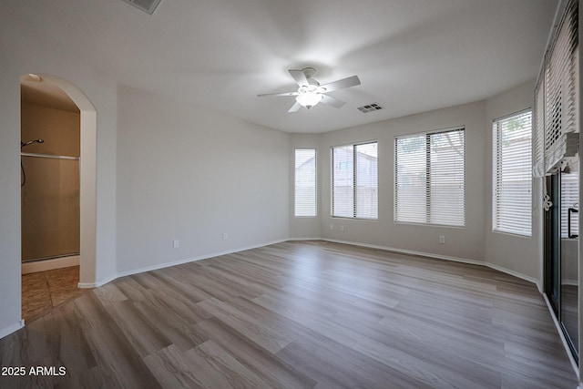 45633 W Mountain View Rd, Maricopa, AZ 85139 - interior space featuring visible vents, wood finished floors, arched walkways, a baseboard heating unit, and a ceiling fan