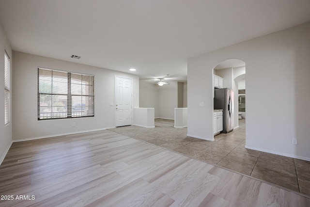 45633 W Mountain View Rd, Maricopa, AZ 85139 - unfurnished living room with arched walkways, a wealth of natural light, ceiling fan, and visible vents