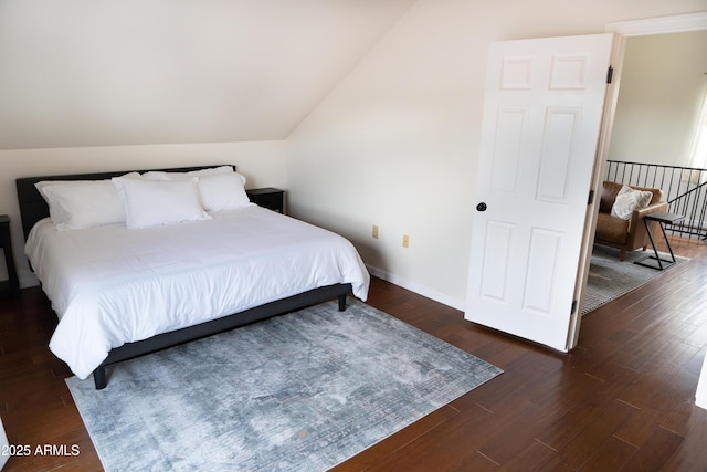 bedroom featuring lofted ceiling, baseboards, and dark wood finished floors