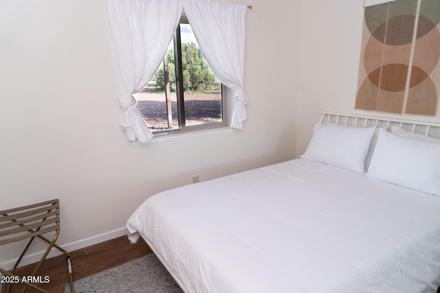 bedroom with dark wood-style floors and baseboards