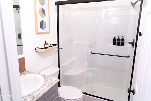 bathroom with a stall shower, vanity, and toilet