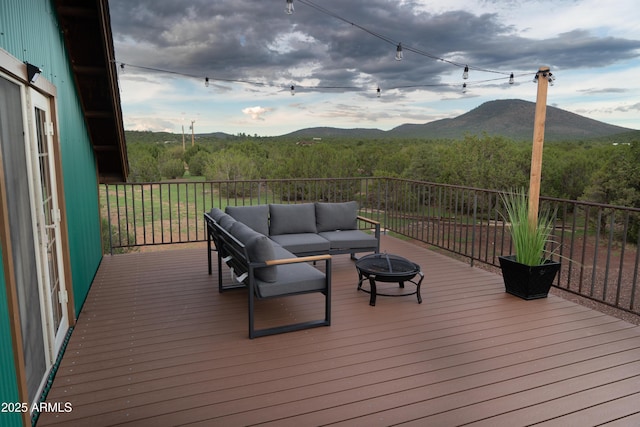 deck with an outdoor living space with a fire pit and a mountain view