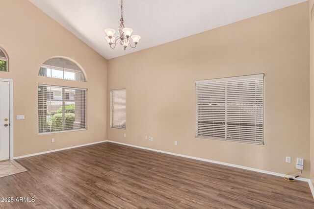 4426 E Coyote Wash Dr, Cave Creek, AZ 85331 - empty room featuring a chandelier, wood finished floors, high vaulted ceiling, and baseboards