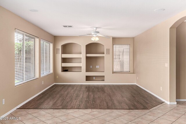 4426 E Coyote Wash Dr, Cave Creek, AZ 85331 - unfurnished living room featuring built in shelves, wood finished floors, baseboards, and ceiling fan