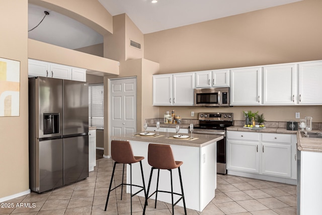 4426 E Coyote Wash Dr, Cave Creek, AZ 85331 - kitchen featuring stainless steel appliances, high vaulted ceiling, light tile patterned floors, white cabinets, and light countertops