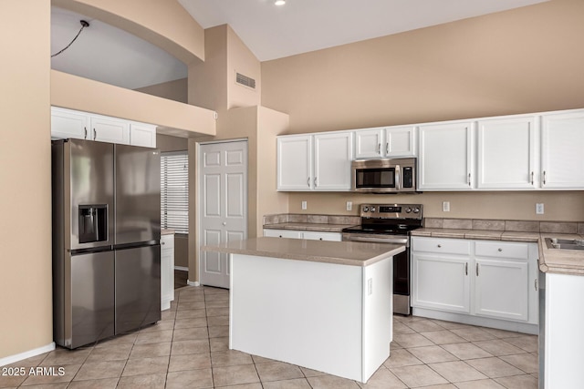 4426 E Coyote Wash Dr, Cave Creek, AZ 85331 - kitchen with appliances with stainless steel finishes, high vaulted ceiling, light tile patterned floors, and white cabinetry