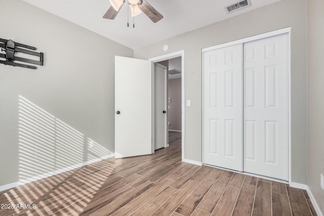 unfurnished bedroom featuring ceiling fan, light hardwood / wood-style floors, and a closet