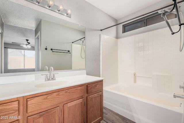 bathroom featuring hardwood / wood-style flooring, ceiling fan, vanity, and tub / shower combination