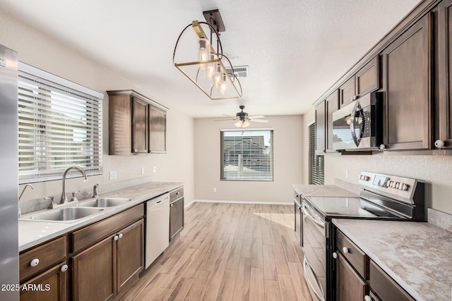 kitchen with a healthy amount of sunlight, appliances with stainless steel finishes, sink, and light hardwood / wood-style flooring