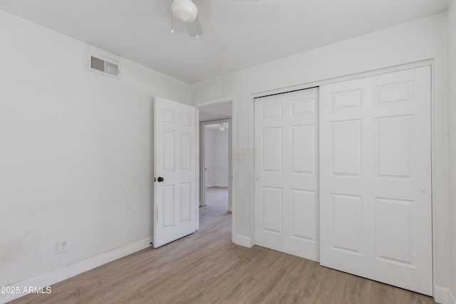 unfurnished bedroom featuring a ceiling fan, visible vents, baseboards, a closet, and light wood-type flooring