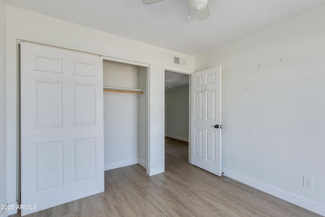 unfurnished bedroom featuring visible vents, a closet, light wood-style flooring, and baseboards