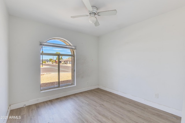 unfurnished room with a ceiling fan, baseboards, and wood finished floors