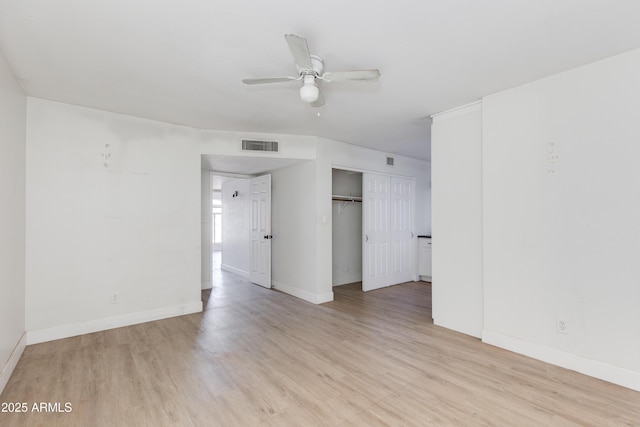 unfurnished room featuring baseboards, a ceiling fan, visible vents, and light wood-style floors