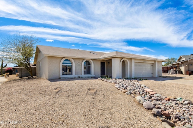 single story home featuring driveway, fence, an attached garage, and stucco siding