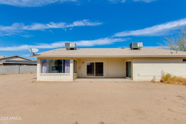 rear view of property featuring a patio area, fence, brick siding, and central AC unit