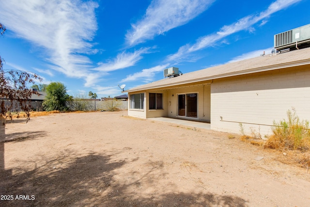 back of property with fence, central AC, and a patio