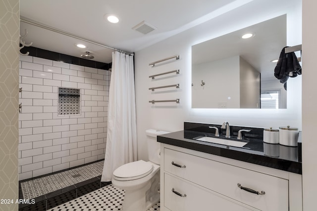 bathroom with walk in shower, tile patterned floors, vanity, and toilet