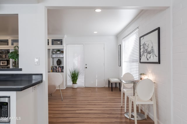 interior space featuring wine cooler, brick wall, and dark hardwood / wood-style floors