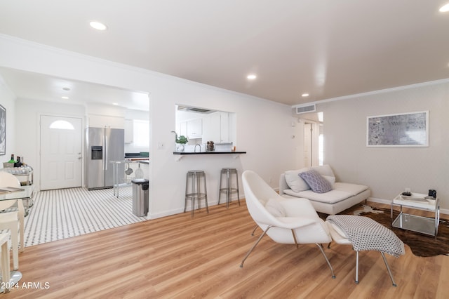 living room featuring ornamental molding and light hardwood / wood-style flooring