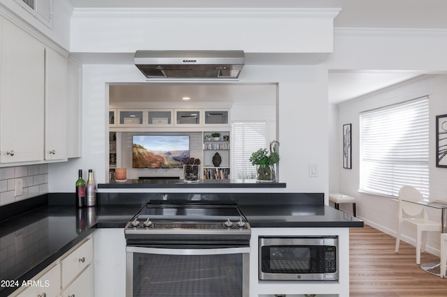 kitchen featuring backsplash, white cabinets, crown molding, light hardwood / wood-style flooring, and stainless steel appliances