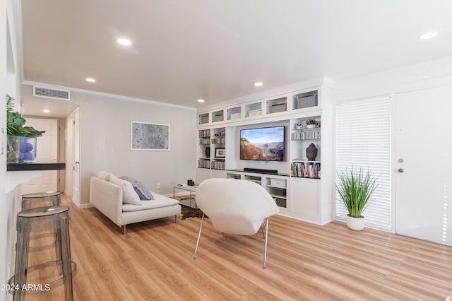 living room featuring light hardwood / wood-style flooring and crown molding