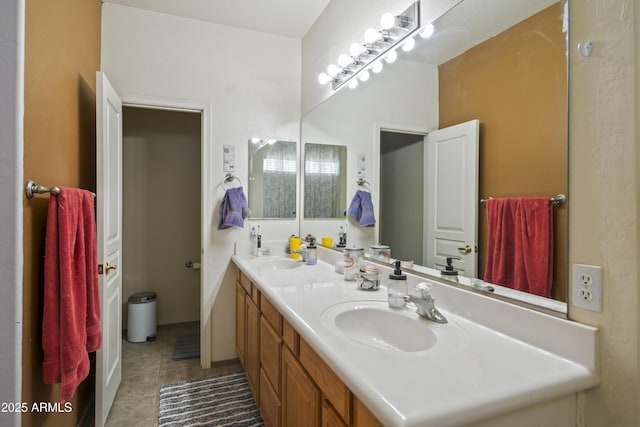 bathroom with a sink, double vanity, and tile patterned flooring
