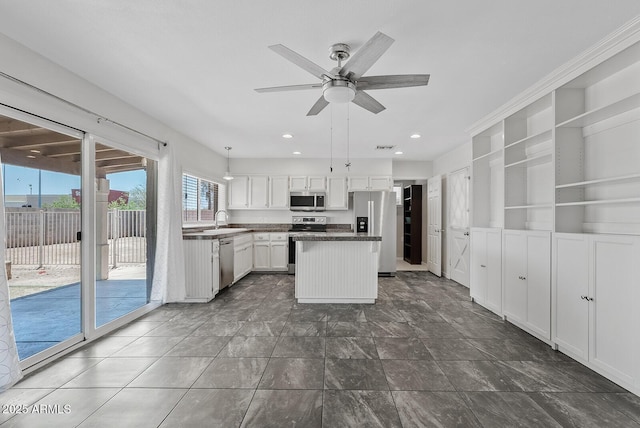 1160 E Hampton Cir, Mesa, AZ 85204 - kitchen with appliances with stainless steel finishes, a ceiling fan, white cabinetry, a center island, and dark countertops