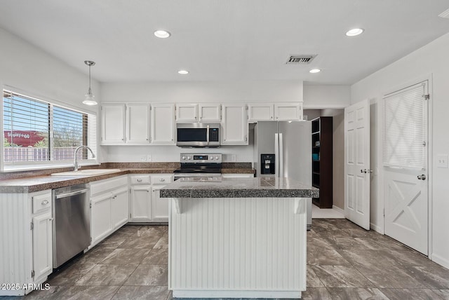 1160 E Hampton Cir, Mesa, AZ 85204 - kitchen with stainless steel appliances, a center island, white cabinetry, decorative light fixtures, and recessed lighting