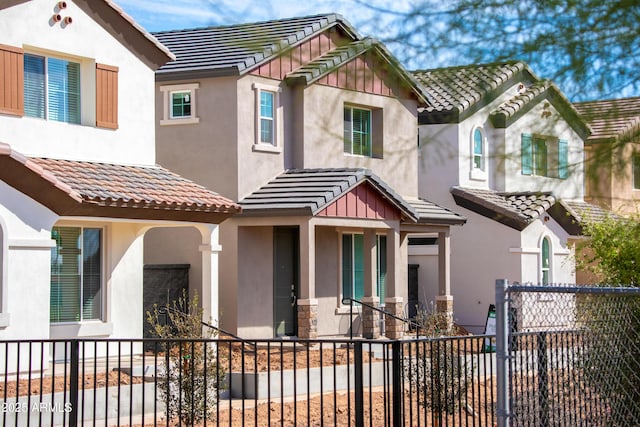 view of front of home featuring a fenced front yard, a tile roof, and stucco siding