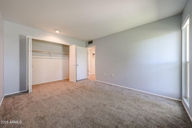 unfurnished bedroom featuring carpet and a closet