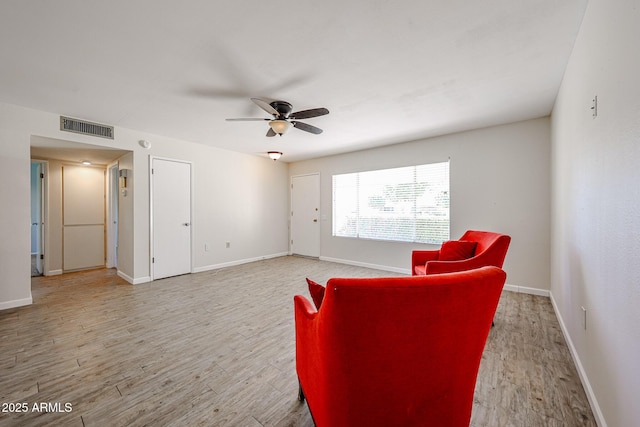 sitting room with ceiling fan and light wood-type flooring