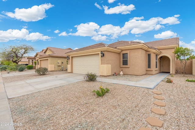 view of front of property with driveway, an attached garage, a tile roof, and stucco siding