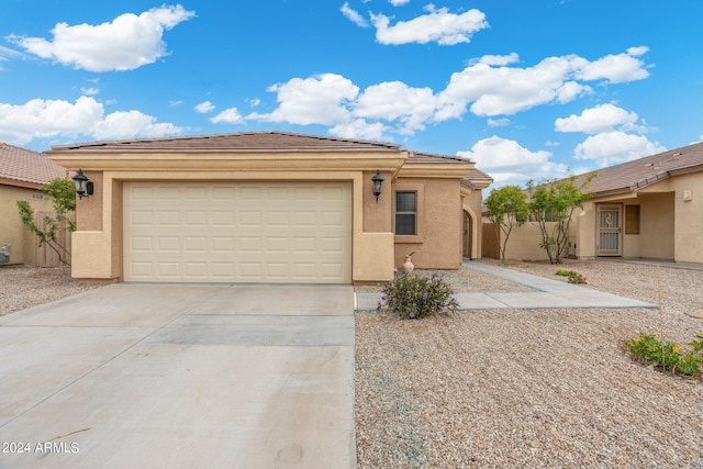 view of front of house with driveway, a garage, and stucco siding