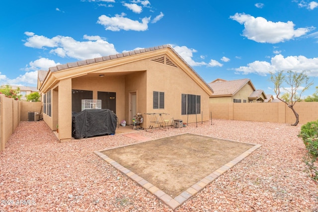 rear view of property featuring a patio, a fenced backyard, a tiled roof, central AC, and stucco siding