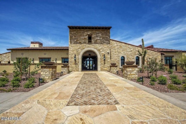 mediterranean / spanish-style house featuring stucco siding, a chimney, and french doors