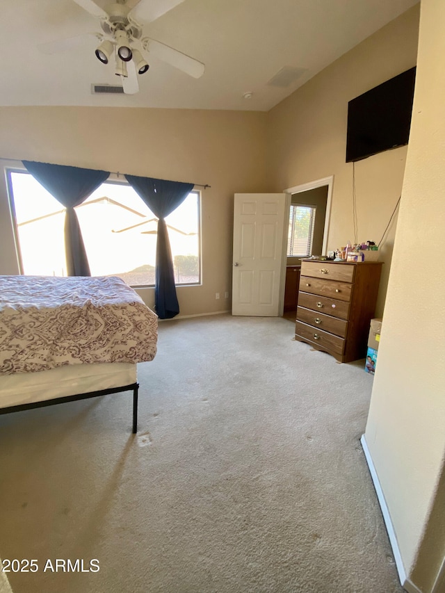 carpeted bedroom with lofted ceiling, multiple windows, and visible vents