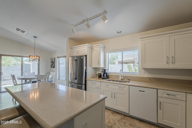 16523 W Desert Bloom St, Goodyear, AZ 85338 - kitchen featuring white dishwasher, freestanding refrigerator, track lighting, white cabinetry, and a chandelier