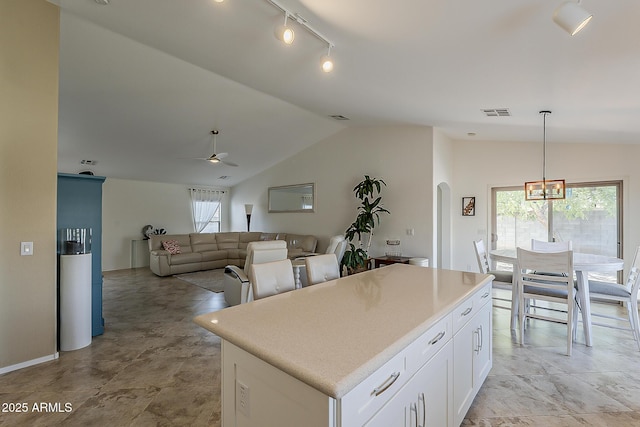 16523 W Desert Bloom St, Goodyear, AZ 85338 - kitchen with vaulted ceiling, a center island, white cabinets, ceiling fan, and rail lighting