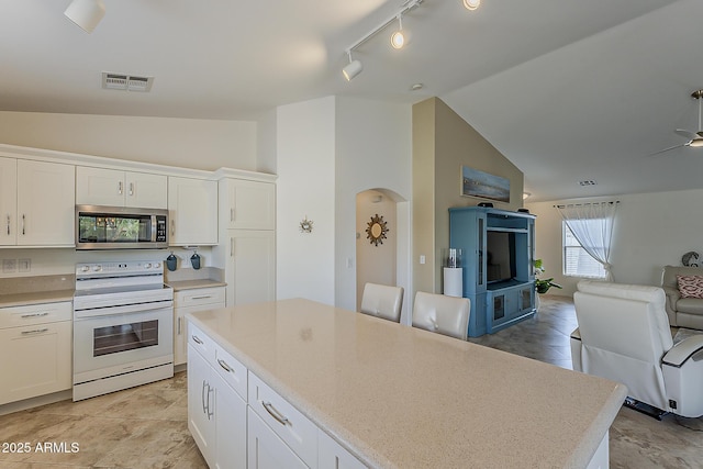 16523 W Desert Bloom St, Goodyear, AZ 85338 - kitchen with stainless steel microwave, white electric range, open floor plan, white cabinetry, and light countertops